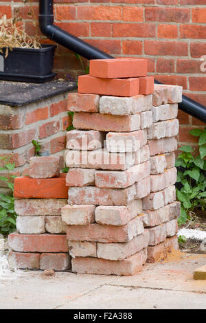Pila di nuovo e usato il rosso dei mattoni Foto Stock
