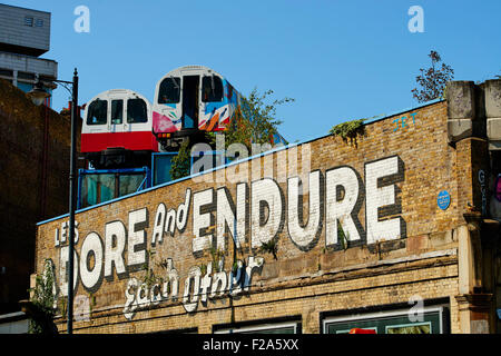 Treno riciclata carrelli usati come artisti sopra il vecchio viadotto ferroviario con pareti utilizzato per arty graffiti, London, Regno Kin Foto Stock