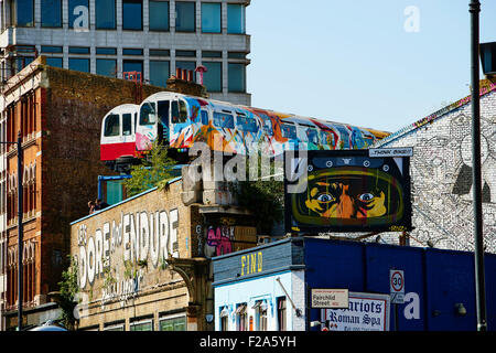 Treno riciclata carrelli usati come artisti sopra il vecchio viadotto ferroviario con pareti utilizzato per arty graffiti, London, Regno Kin Foto Stock