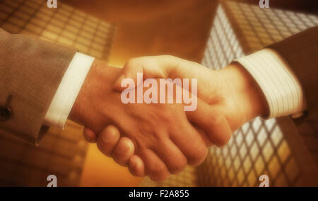 Contabilità aziendale equilibrio. Handshake con moderni grattacieli come sfondo. Foto Stock