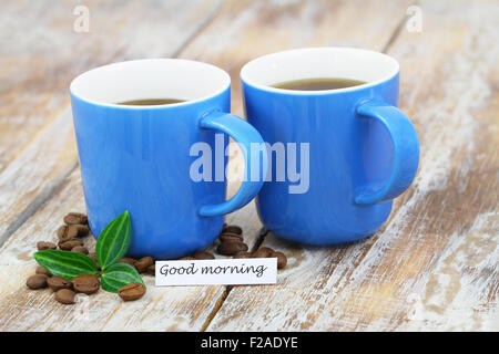 Buona mattina card con blu di due tazze di caffè sulla superficie rustico Foto Stock