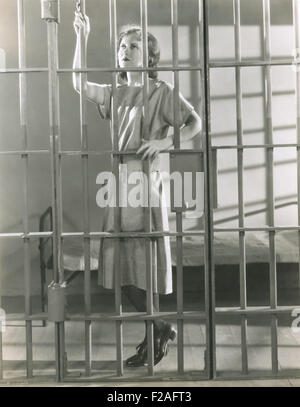 Giovane donna in piedi in cella di prigione (OLVI008 OU322 F) Foto Stock