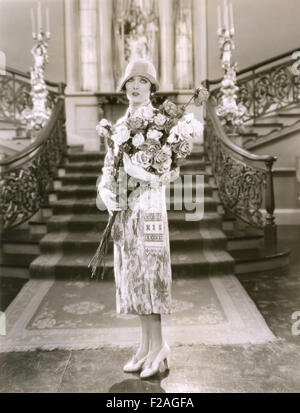 Donna che mantiene grandi bouquet di fiori (OLVI008 OU132 F) Foto Stock