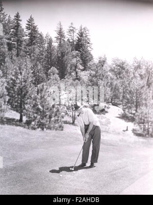 Uomo di fumare tubo mentre giocando a golf (OLVI007 OU991 F) Foto Stock