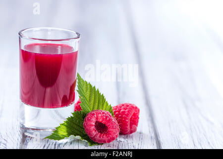 Liquore di lamponi con alcuni frutti freschi in un bicchiere Foto Stock