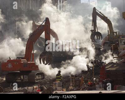 Ground Zero smolders ancora come operazioni di recupero continuare un mese dopo l'attacco terroristico. Il 10 di ottobre, 2001. Attrezzatura di scavo funziona in coordinamento con gli operatori di soccorso. World Trade Center di New York City, dopo l'11 settembre 2001 attacchi terroristici. (BSLOC 2015 2 116) Foto Stock