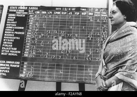 Primo Ministro indiano Indira Gandhi accanto a una bacheca mostrando elezioni anticipate restituisce. Febbraio 28, 1967. Con schede contate Foto Stock