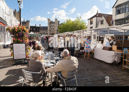 La gente seduta in pozzetti di mercato, il Marketplace, pozzi, Somerset England Regno Unito Foto Stock