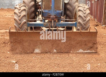 Close-up aratro trattore su terra rossa, Thailandia Foto Stock