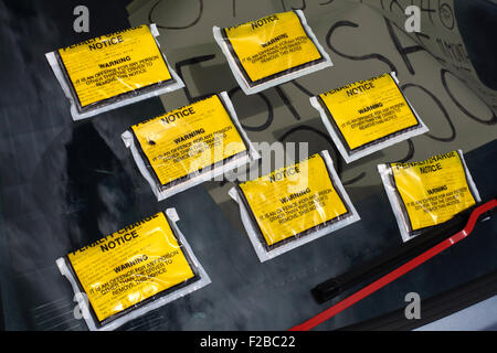 Sette i biglietti per il parcheggio sul parabrezza di un illegalmente parcheggiato l'auto. Foto Stock