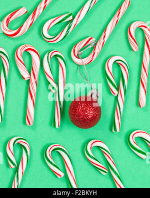 Raccolta di candy canes con ornamento rosso su sfondo verde. Foto Stock