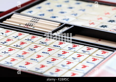 Mahjong mah jongg il gioco d'azzardo scatola aperta, con contenuti visualizzati, vari piastrella o tute di carta, gruppi ordinati per numero su sfondo bianco Foto Stock