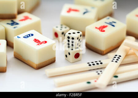 Mahjong Mah Jong il gioco d'azzardo set. Varie carte o piastrelle, dadi e alcuni contatori posa su sfondo bianco. Foto Stock