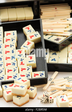 Mahjong Mah Jong il gioco d'azzardo box set, aprire con contenuti rimuovere parzialmente. Vari vassoi di nero con set o tute di carte e piastrelle sfondo bianco. Foto Stock