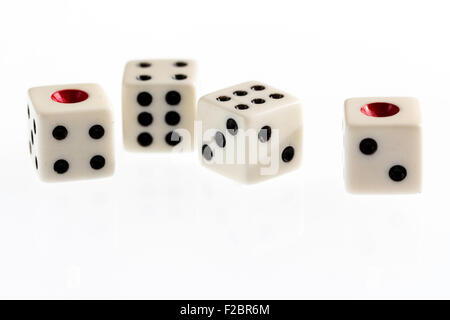 Quattro dadi bianco con macchie nere e rosse uno singolo sul bianco illuminato sfondo semplice. Foto Stock