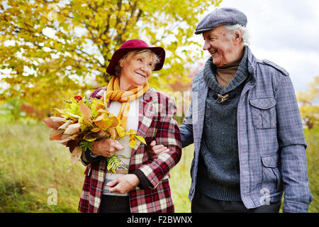 Seniors romantico prendendo a piedi nel parco in autunno Foto Stock