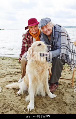 Coppia in pensione con labrador trascorrendo del tempo da mare Foto Stock