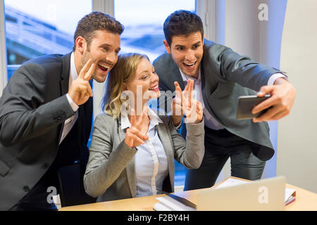Ritratto di tre sucessful business persone prendendo un selfie con lo smartphone Foto Stock