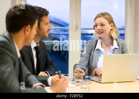 Imprenditrice a discutere con i colleghi in ufficio Foto Stock