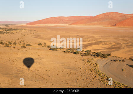 Ombra della mongolfiera su una pianura arida e il secco alveo del Tsauchab River a bordo del Namib Desert, Foto Stock