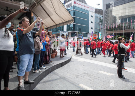 Kuala Lumpur, Malesia. Xvi Sep, 2015. La gente guarda su come pro-governo maglietta rossa manifestanti prendere parte in una dimostrazione di Kuala Lumpur in Malesia, mercoledì 16 settembre, 2015. Migliaia di pro-Malay i dimostranti sono scesi per le strade di Kuala Lumpur il mercoledì in un rally visto come promuovere la supremazia malay nel multi-razziale nazione. Alti esponenti politici e partiti di opposizione hanno espresso la loro preoccupazione il rally potrebbe infiammare le tensioni razziali in un momento in cui il Primo Ministro Najib Razak è sotto intensa pressione a dimettersi su un presunto scandalo di corruzione. Credito: Asia File/Alamy Live News Foto Stock