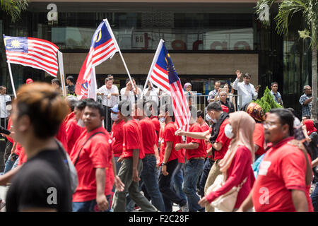 Kuala Lumpur, Malesia. Xvi Sep, 2015. La gente guarda su come pro-governo maglietta rossa manifestanti prendere parte in una dimostrazione di Kuala Lumpur in Malesia, mercoledì 16 settembre, 2015. Migliaia di pro-Malay i dimostranti sono scesi per le strade di Kuala Lumpur il mercoledì in un rally visto come promuovere la supremazia malay nel multi-razziale nazione. Alti esponenti politici e partiti di opposizione hanno espresso la loro preoccupazione il rally potrebbe infiammare le tensioni razziali in un momento in cui il Primo Ministro Najib Razak è sotto intensa pressione a dimettersi su un presunto scandalo di corruzione. Credito: Asia File/Alamy Live News Foto Stock