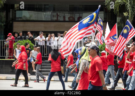 Kuala Lumpur, Malesia. Xvi Sep, 2015. La gente guarda su come pro-governo maglietta rossa manifestanti prendere parte in una dimostrazione di Kuala Lumpur in Malesia, mercoledì 16 settembre, 2015. Migliaia di pro-Malay i dimostranti sono scesi per le strade di Kuala Lumpur il mercoledì in un rally visto come promuovere la supremazia malay nel multi-razziale nazione. Alti esponenti politici e partiti di opposizione hanno espresso la loro preoccupazione il rally potrebbe infiammare le tensioni razziali in un momento in cui il Primo Ministro Najib Razak è sotto intensa pressione a dimettersi su un presunto scandalo di corruzione. Credito: Asia File/Alamy Live News Foto Stock