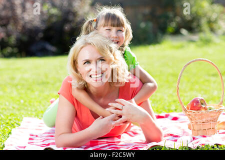 La famiglia felice giacente in erba in estate o in autunno Foto Stock