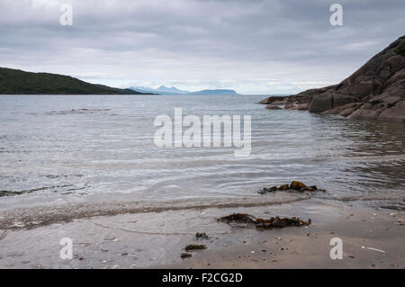 Guardando fuori il rum, Eigg e Muck dal cantare Sands, Kentra Bay, a Ardnamurchan, Scozia Foto Stock