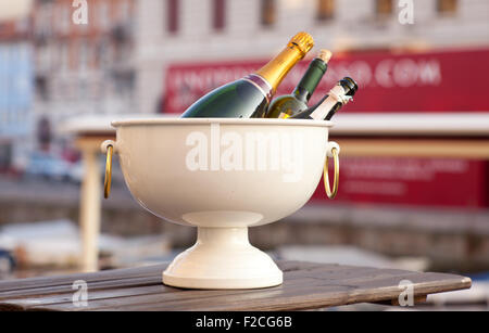 Bottiglie di vino spumante in una vasca con ghiaccio Foto Stock