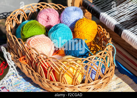 Bright multi-palle colorate di filato nel cesto di vimini Foto Stock