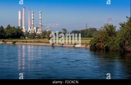 Un canale con una centrale termica e di montagna come sfondo di Turbigo, Italia Foto Stock