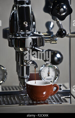 Acciaio inossidabile macchina espresso in azione con marrone espresso cup Foto Stock