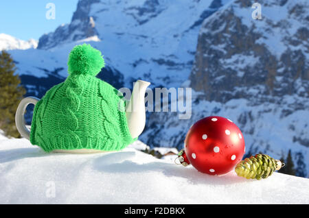 Tè pentola nel tappo contro il paesaggio alpino Foto Stock