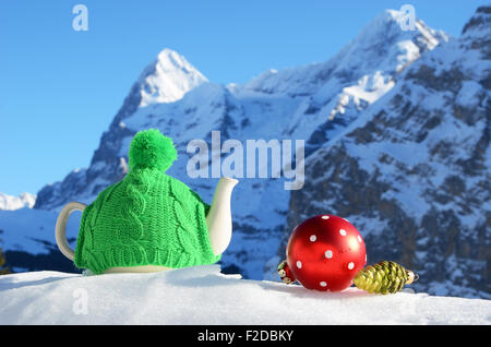 Tè pentola nel tappo contro il paesaggio alpino Foto Stock