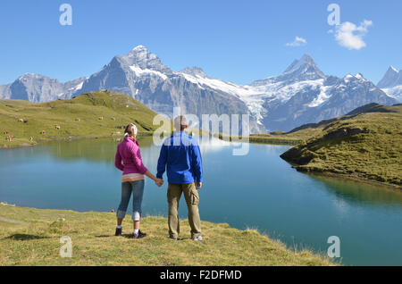 I viaggiatori godendo panorama alpino. Regione di Jungfrau, Svizzera Foto Stock