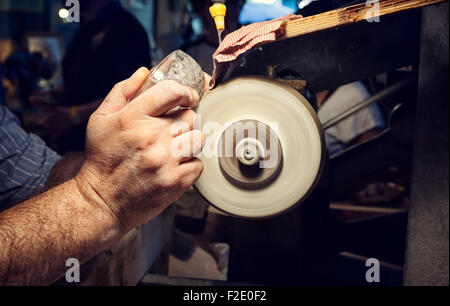 In prossimità delle mani di un artigiano durante la levigazione di un portacenere di cristallo Foto Stock