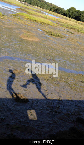 Le ombre dei ragazzi giocare (uno calci gli altri) Allee des Freres Cadoret, Presqu'ile de conleau, Vannes, Bretagna Francia Foto Stock