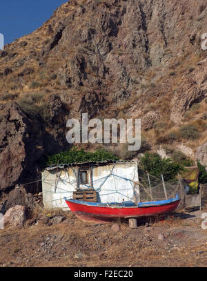 Piccolo capanno e una barca di fronte hill Foto Stock