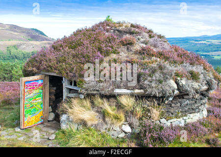 Sentiero ABRIACHAN o camminare sopra LOCH NESS LA CAPANNA SHIELING CON VIOLA HEATHER tetto nella tarda estate Foto Stock