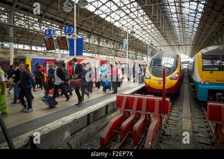 Stazione ferroviaria Manchester Piccadilly vergine logo su un treno pendolino da Londra passeggeri in transito a piedi sfocate su occupato Foto Stock