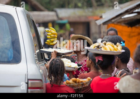 Locali di donne malgasce la vendita delle banane e cibo ai passanti di viaggiare nel veicolo nel villaggio rurale in Madagascar, Africa Foto Stock