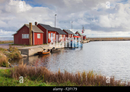 Red case di pescatori / rorbuer cabine e la pesca in barca nel porto di Graesgard / Gräsgård, Öland, Svezia Foto Stock