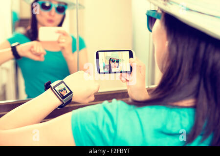 Donna prendendo autoritratto selfie foto e lo invia a smartwatch. Foto Stock