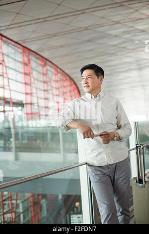 Uomo maturo in attesa in aeroporto Foto Stock