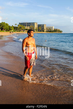 Uomo alla spiaggia di Kaanapali di Maui vicino Black Rock al tramonto Foto Stock