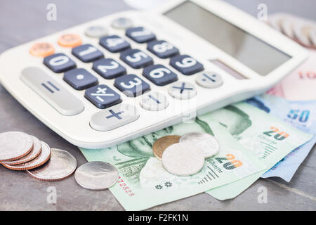 Calcolatrice con denaro su sfondo grigio, stock photo Foto Stock