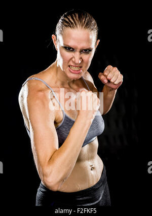 Close up aggressivo donna atletica in posa di combattimento Foto Stock