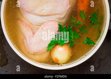 Pollo con cipolle, carote, prezzemolo in brodo vista superiore Foto Stock