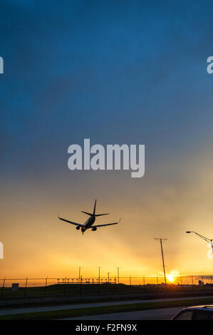 Delta Airlines jet in atterraggio a Atlanta Aeroporto internazionale contro la brillante sullo sfondo di una vivida Cielo di tramonto. (USA) Foto Stock